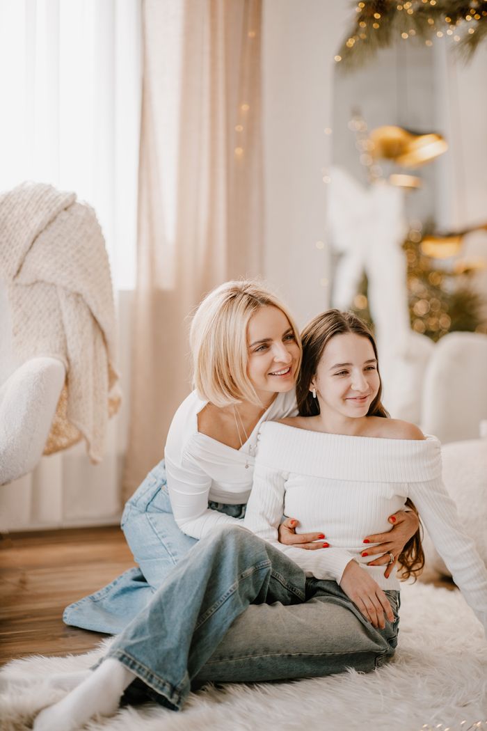 Joyful mother and daughter in cozy home setting embracing and smiling.